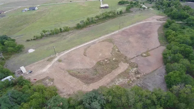 an aerial view of a house with a yard and greenery