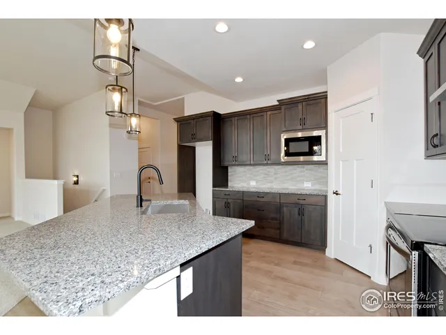 a kitchen with kitchen island granite countertop a sink counter top space appliances and cabinets