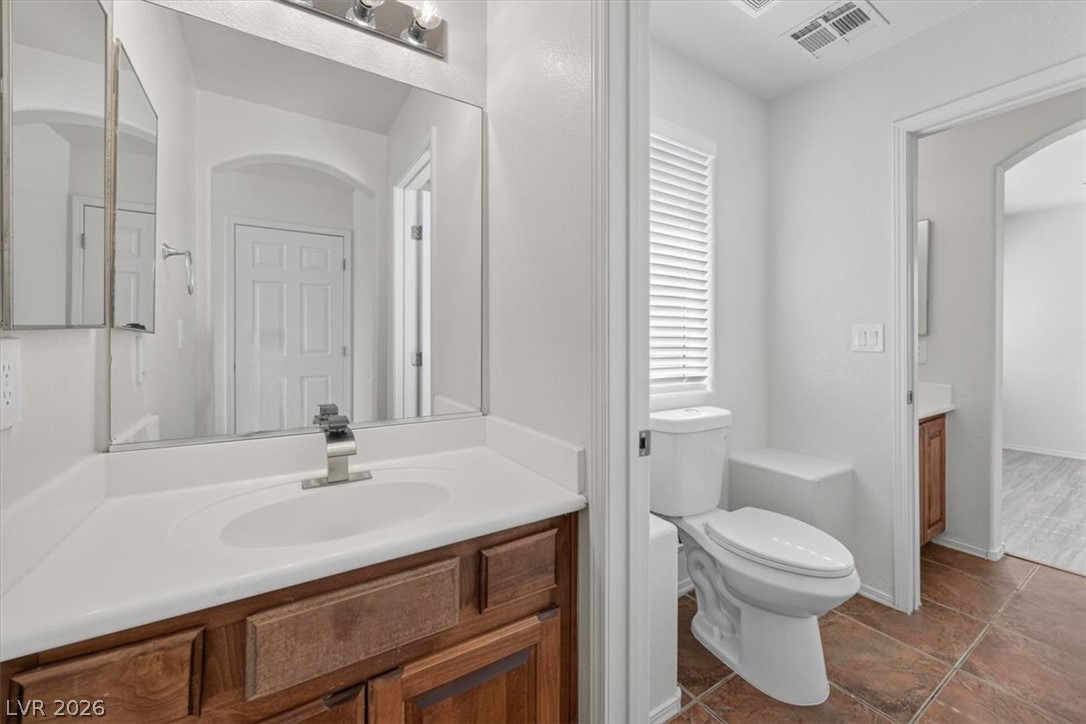 552 Albacate Street Henderson, NV 89015 - Photo 30 of 40 A well-appointed bathroom features a single vanity, a window with natural light, and tiled flooring.