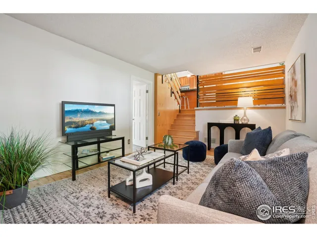 a living room with furniture and a painting on the wall