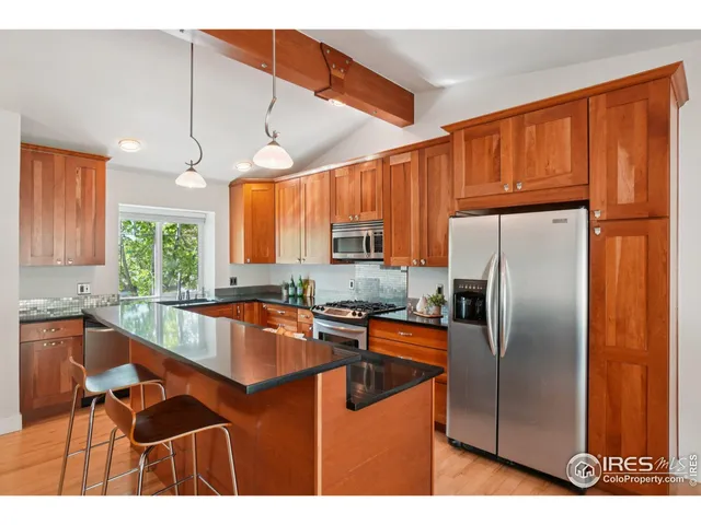 a kitchen with stainless steel appliances granite countertop a refrigerator a sink a stove and island