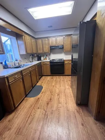 a large kitchen with a sink and wooden cabinets