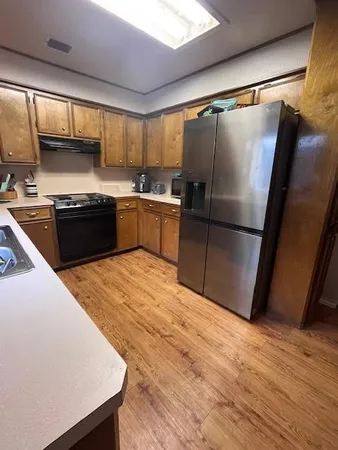 a large kitchen with a stove a refrigerator and a sink