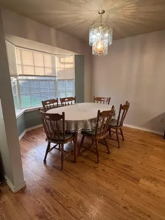 a view of a dining room with furniture a chandelier and wooden floor