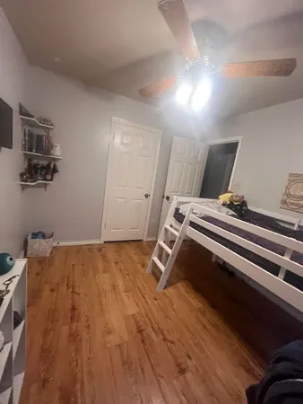 a bedroom with a bed and wooden floor
