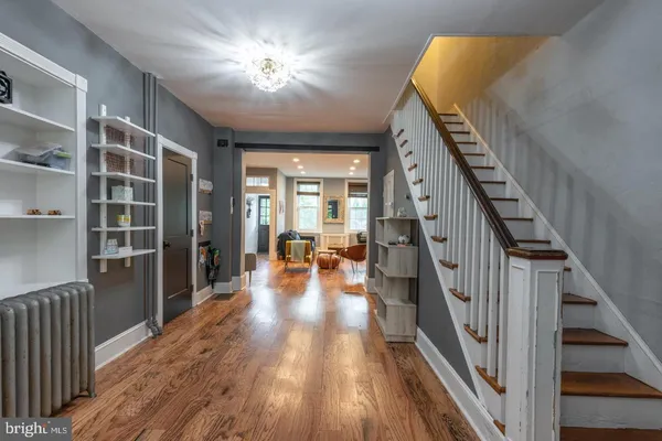 a view of a hallway with wooden floor and staircase