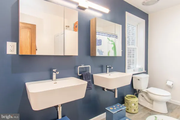 a bathroom with a toilet sink and mirror