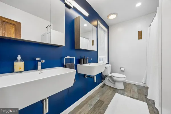 a bathroom with a sink a toilet and mirror
