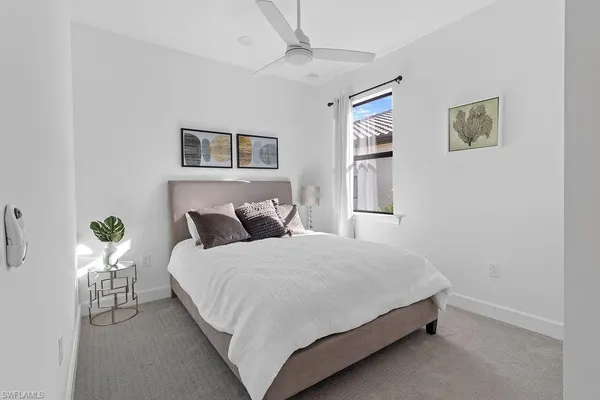 a bedroom with a bed and painting on the wall