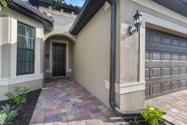 a view of a house with a yard and potted plants