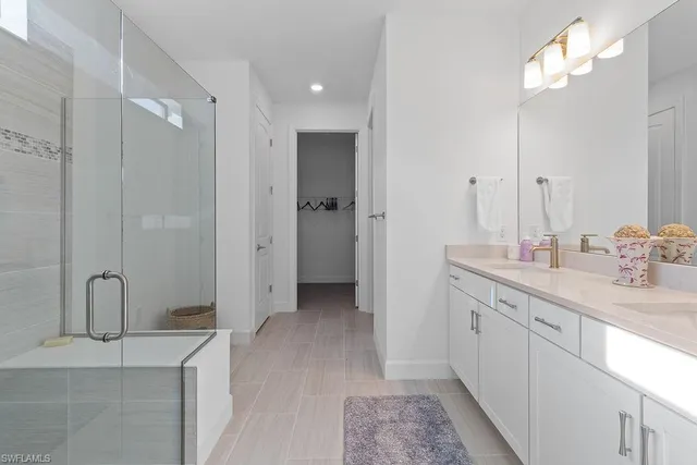 a spacious bathroom with a double vanity sink a mirror and shower