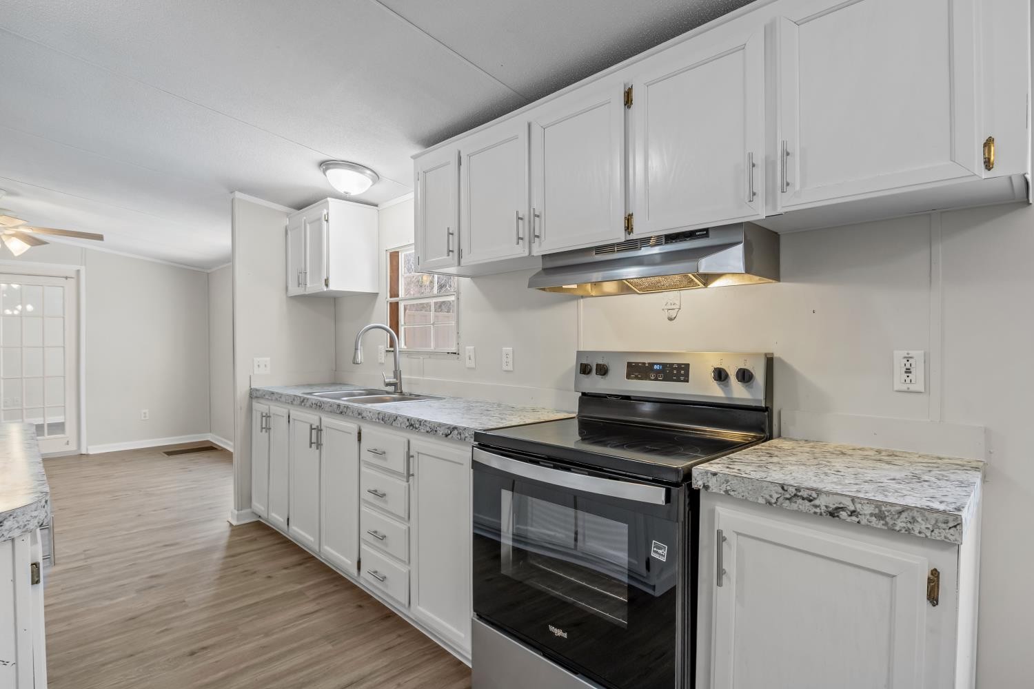 624 Nickletown Road Sugar Tree, TN 38380 - Photo 15 of 45 a kitchen with granite countertop white cabinets and stainless steel appliances