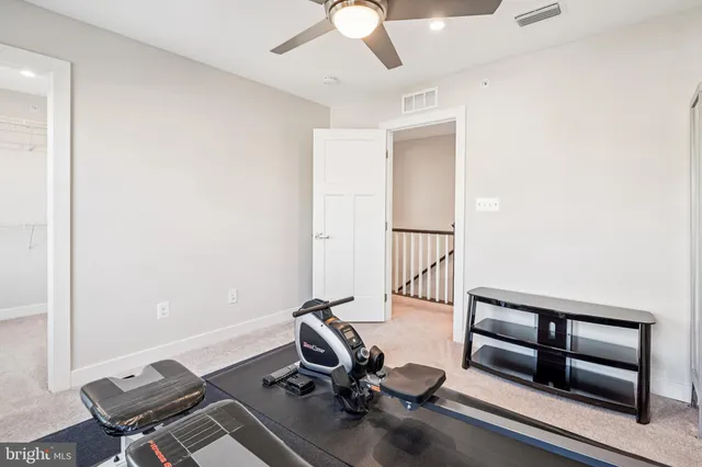 a living room with furniture a flat screen tv and gym equipment