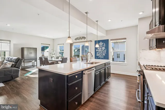 a kitchen with stainless steel appliances granite countertop a sink a stove and a refrigerator