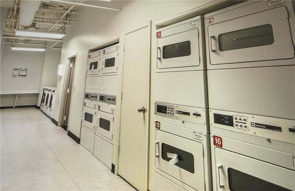 20 Marietta Street Northwest, Unit 10F Atlanta, GA 30303 - Photo 14 of 17 a view of washer and dryer with white cabinets