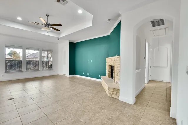 a view of an empty room with a window and a kitchen