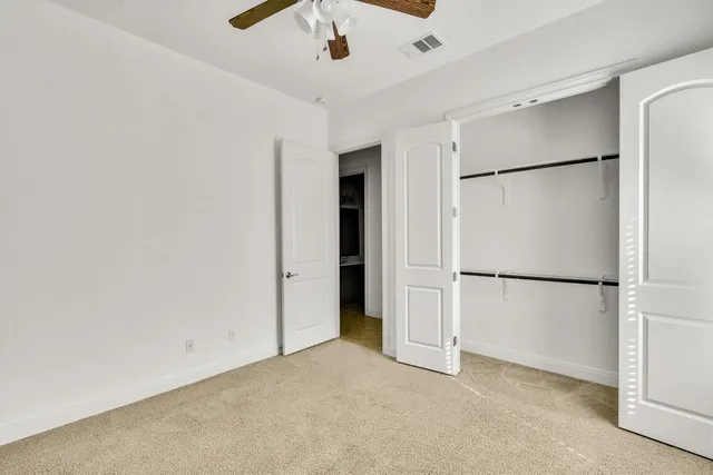 a view of a refrigerator in kitchen and white cabinets