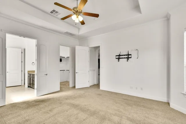 an empty room with closet and a ceiling fan