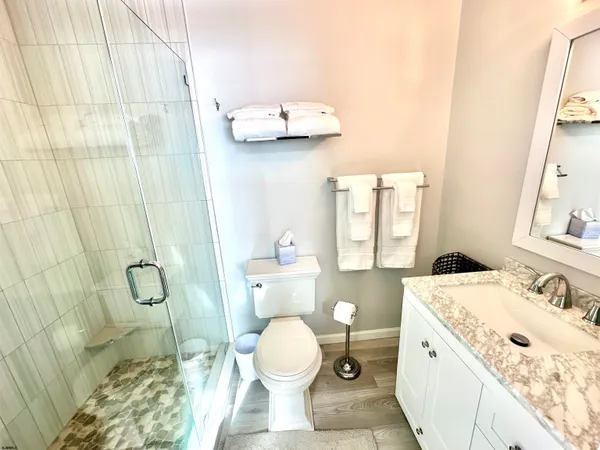 a bathroom with a granite countertop sink toilet and shower