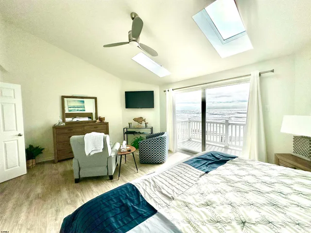 a bedroom with a bed a couch and a flat screen tv