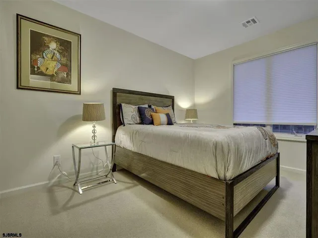 a bedroom with a bed and painting on the wall