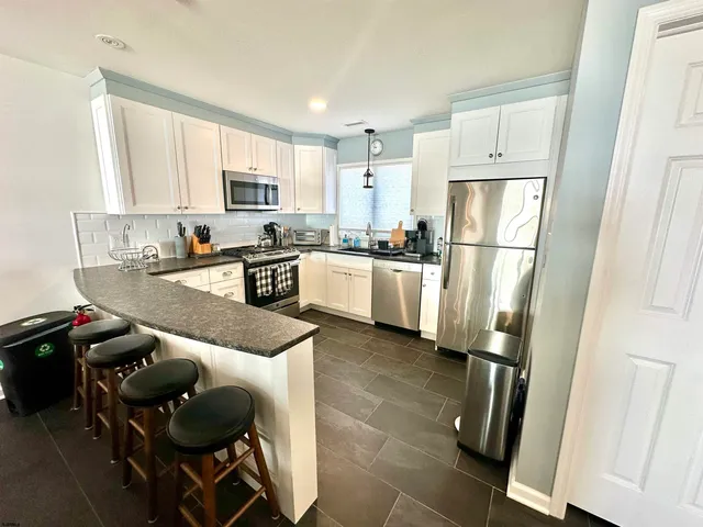 a kitchen with a refrigerator a stove a microwave and cabinets