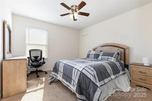 a bedroom with a bed and a ceiling fan