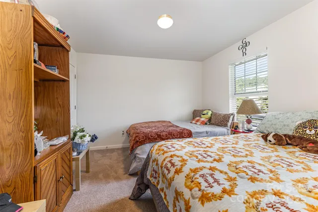 a bedroom with two beds and a chandelier