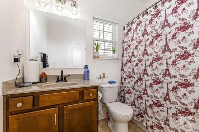 a bathroom with a granite countertop sink a toilet and a mirror