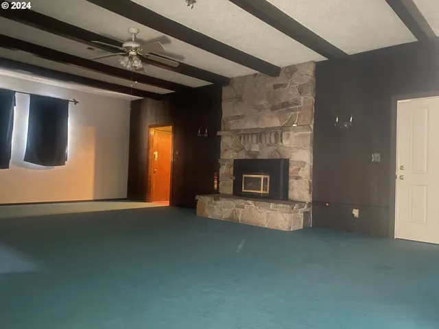 an empty room with a fireplace and fan