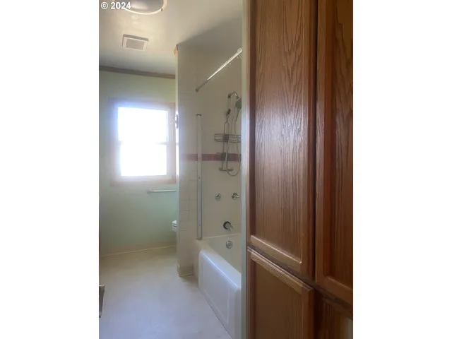 a bathroom with a granite countertop sink a toilet and shower