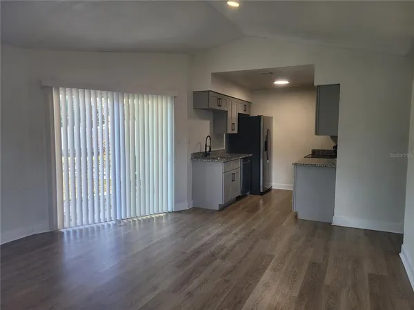 a view of kitchen with wooden floor electronic appliances and window