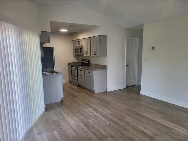 a view of kitchen with stainless steel appliances kitchen island wooden floors and stove