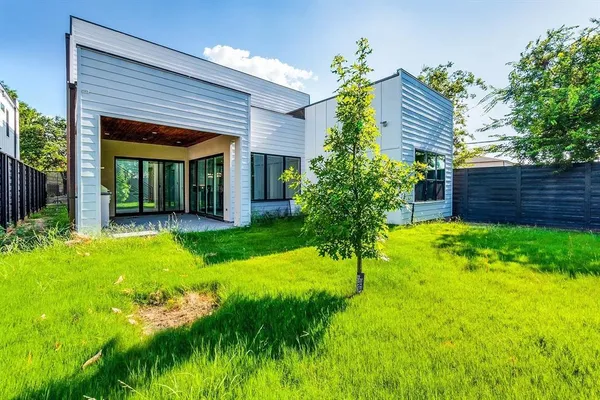 a view of house with backyard and a garden