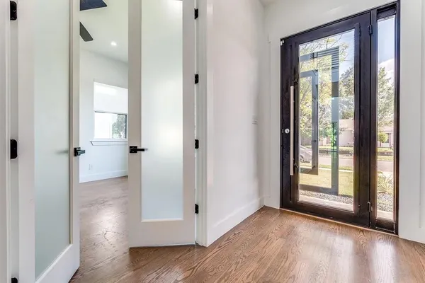 a view of a hallway with wooden floor and a cabinet