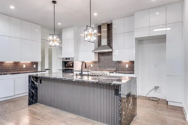 a kitchen with stainless steel appliances granite countertop a sink a stove and a refrigerator