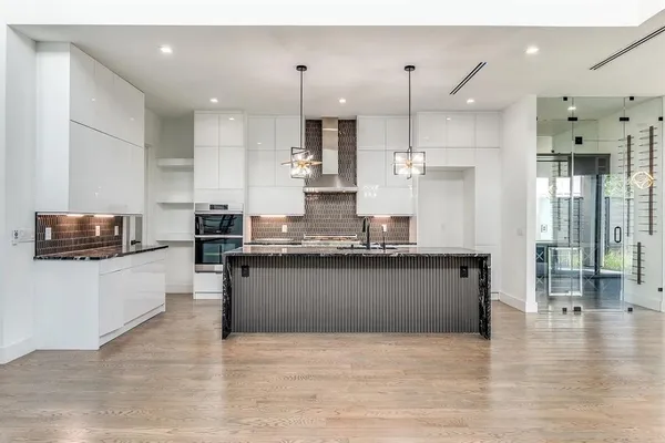 a large kitchen with granite countertop a large counter top stainless steel appliances and cabinets