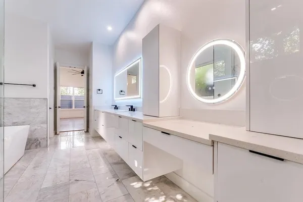 a spacious bathroom with a granite countertop sink mirror and bathtub