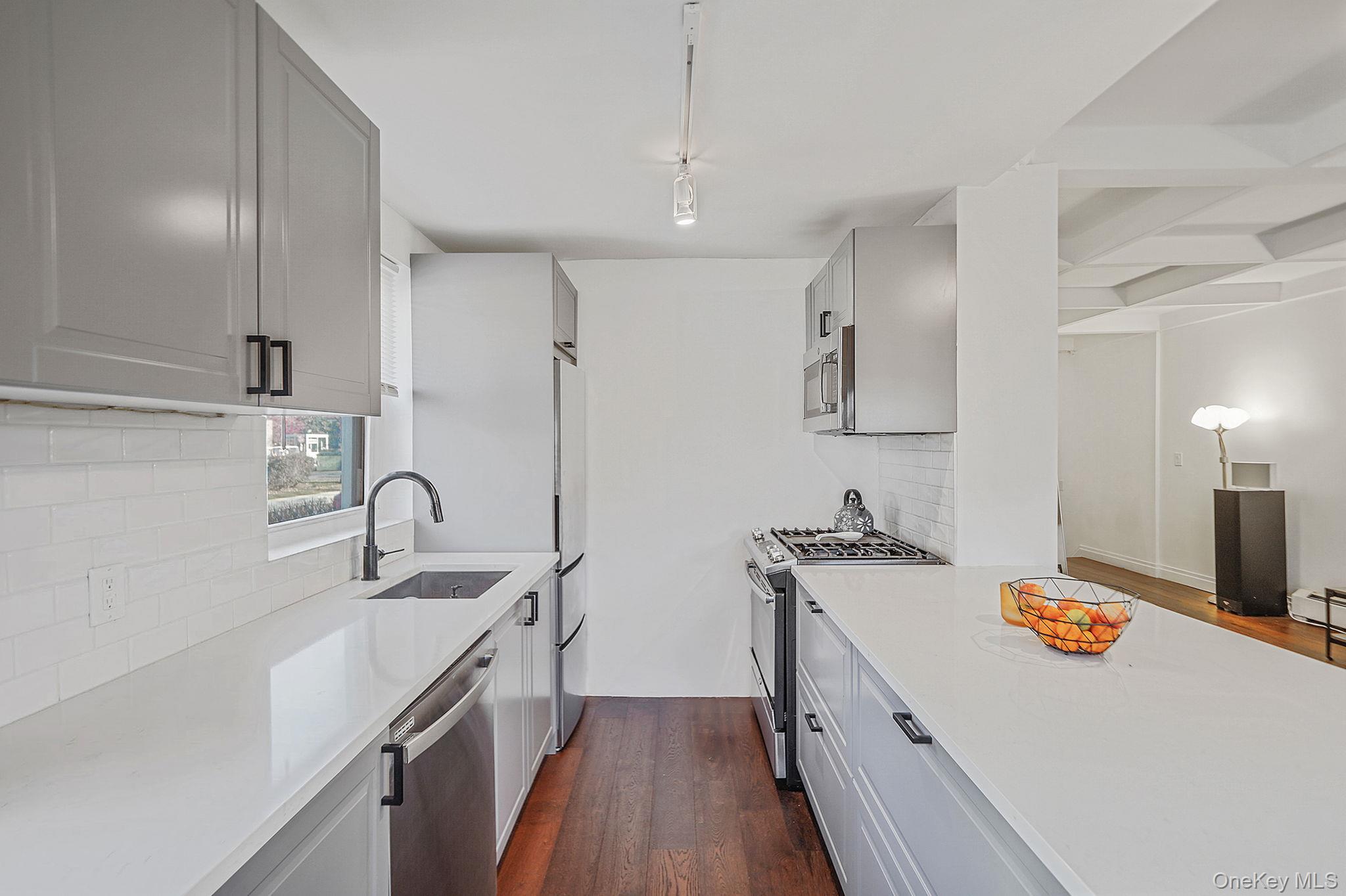 144-66 Village Road, Unit 75D Queens, NY 11435 - Photo 6 of 19 a kitchen with a sink a stove and refrigerator