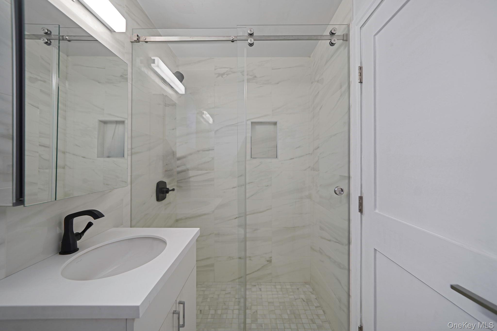 144-66 Village Road, Unit 75D Queens, NY 11435 - Photo 9 of 19 a bathroom with a sink and shower