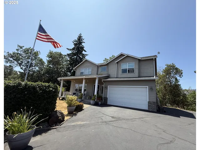 a front view of a house with a yard and potted plants