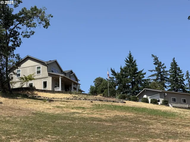 a front view of a house with a yard and trees