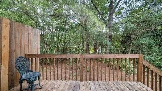 a wooden deck with trees in the background