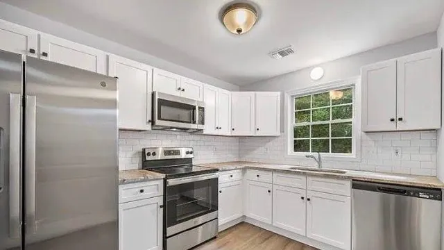 a kitchen with a sink a window and stainless steel appliances