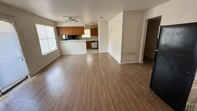 wooden floor in an empty room with a kitchen