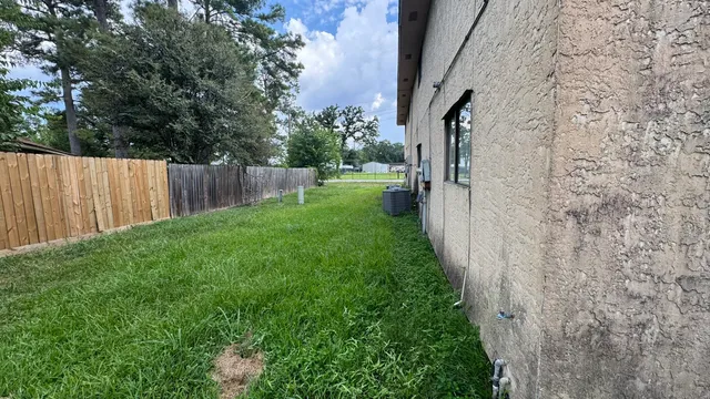 a view of backyard with potted plants and wooden fence