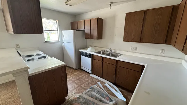 a kitchen with a sink a refrigerator and window