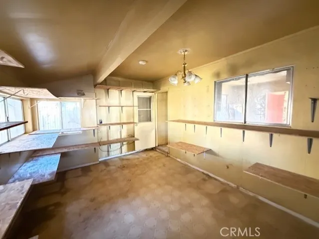 an empty room with kitchen and windows