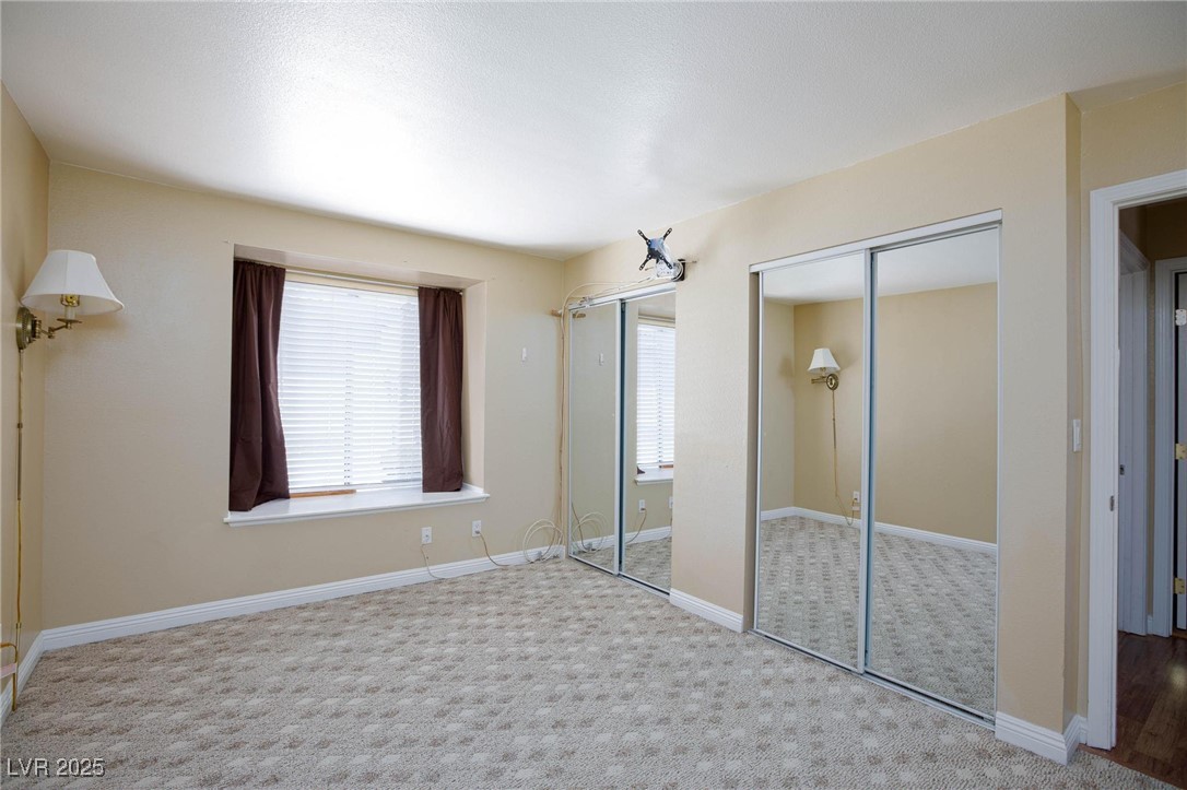 7300 West Pirates Cove Road, Unit 2038 Las Vegas, NV 89145 - Photo 12 of 26 Unfurnished bedroom with multiple closets and carpet flooring