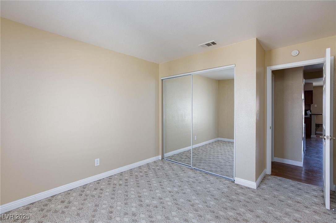 7300 West Pirates Cove Road, Unit 2038 Las Vegas, NV 89145 - Photo 17 of 26 Unfurnished bedroom with light colored carpet and a closet